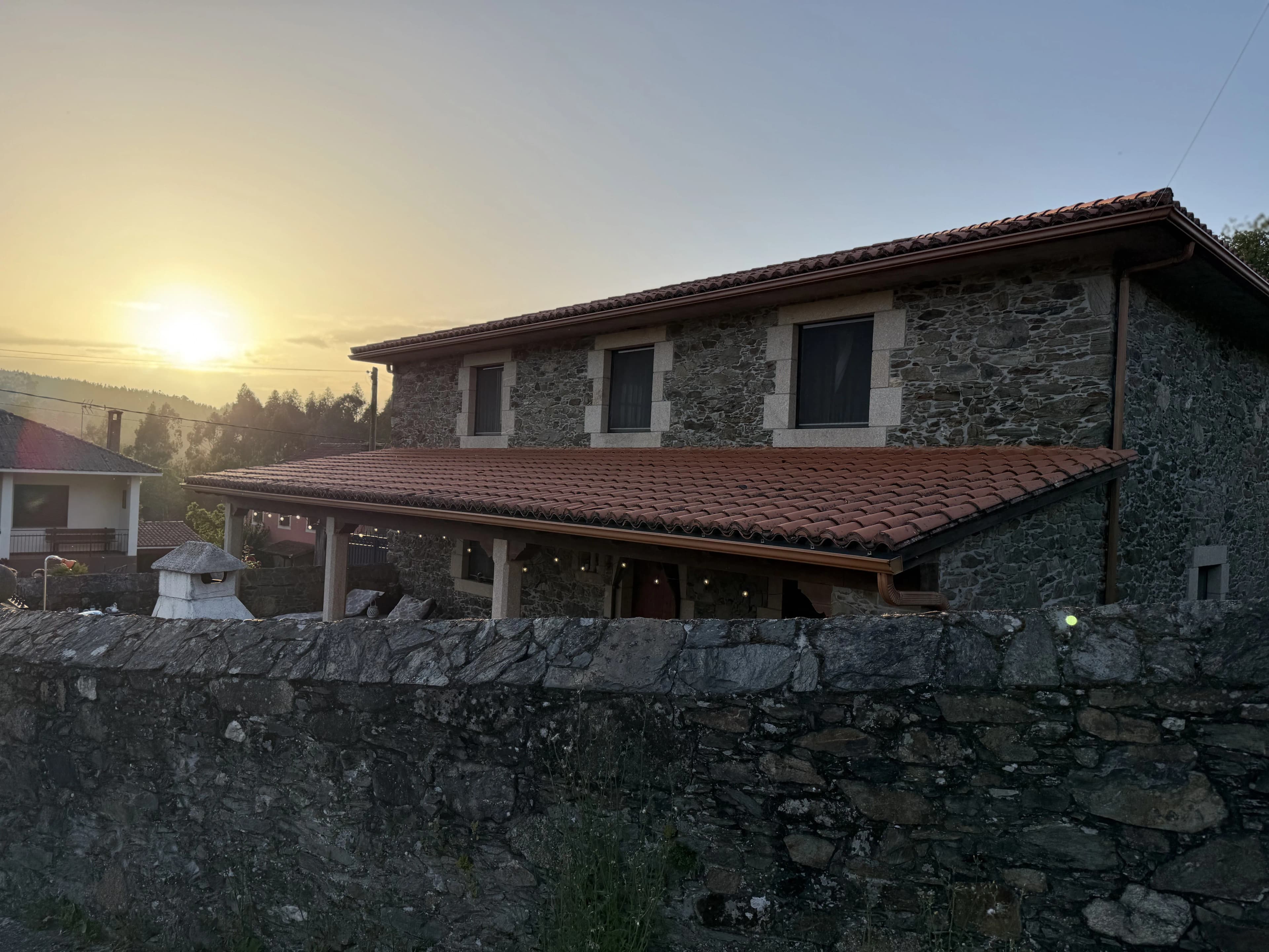 Fachada de O Lar do Carpinteiro iluminada al atardecer en Oza dos Ríos